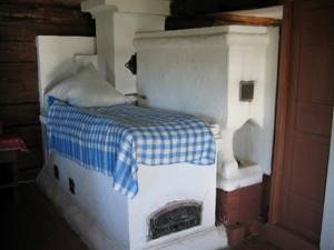 Белая кирпичная печь с лежаком-постелью