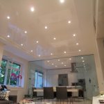 Фото глянцевый натяжной потолок с встроенными светильниками в гостиной, совмещенной с кухней