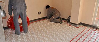 работники укладывают теплый пол